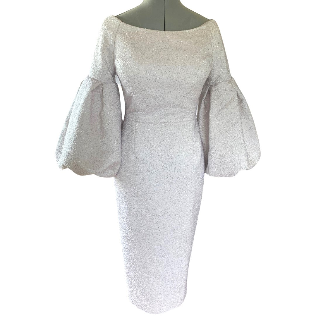 A luxurious boat neck fitted and tailored dress offering a unique twist with an oversized volume cuff.