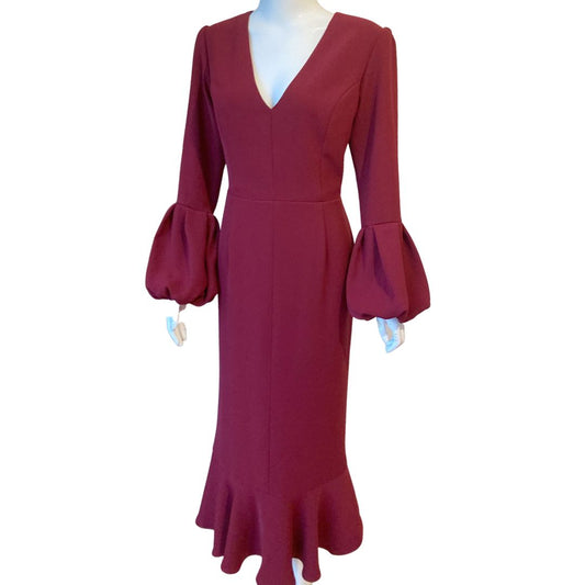 V Neck maxi with a sleeve finishing in a draped volume cuff. This fitted dress longer length is softened by a lower flounce creating a flirty finish