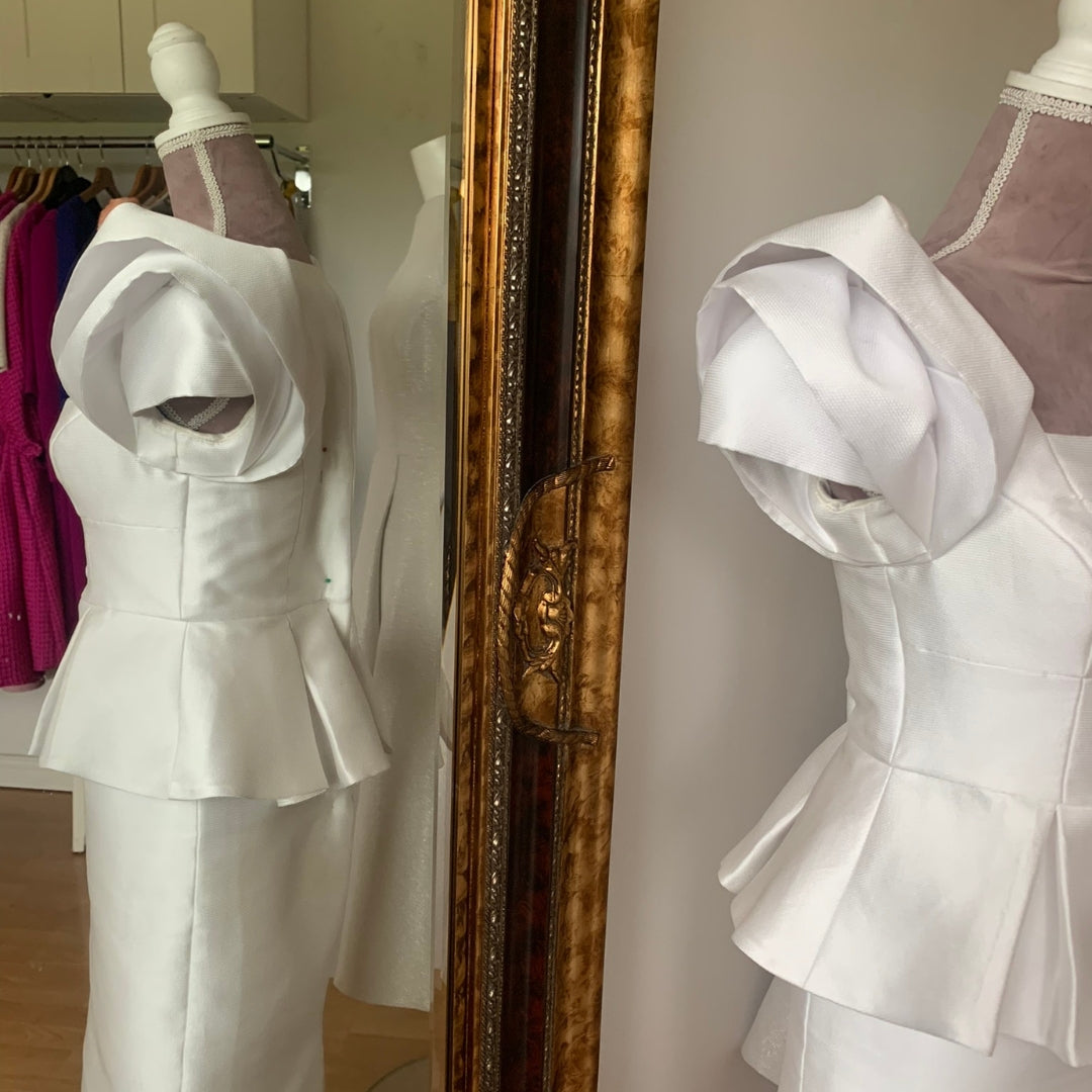 Carmen Sydney Two Piece Skirt & Top suit. Made in a light texture Mikado Ivory Fabric, fully lined in Satin. Featuring button front detail and Dramatic Shoulder in a Layered Rose Effect.
