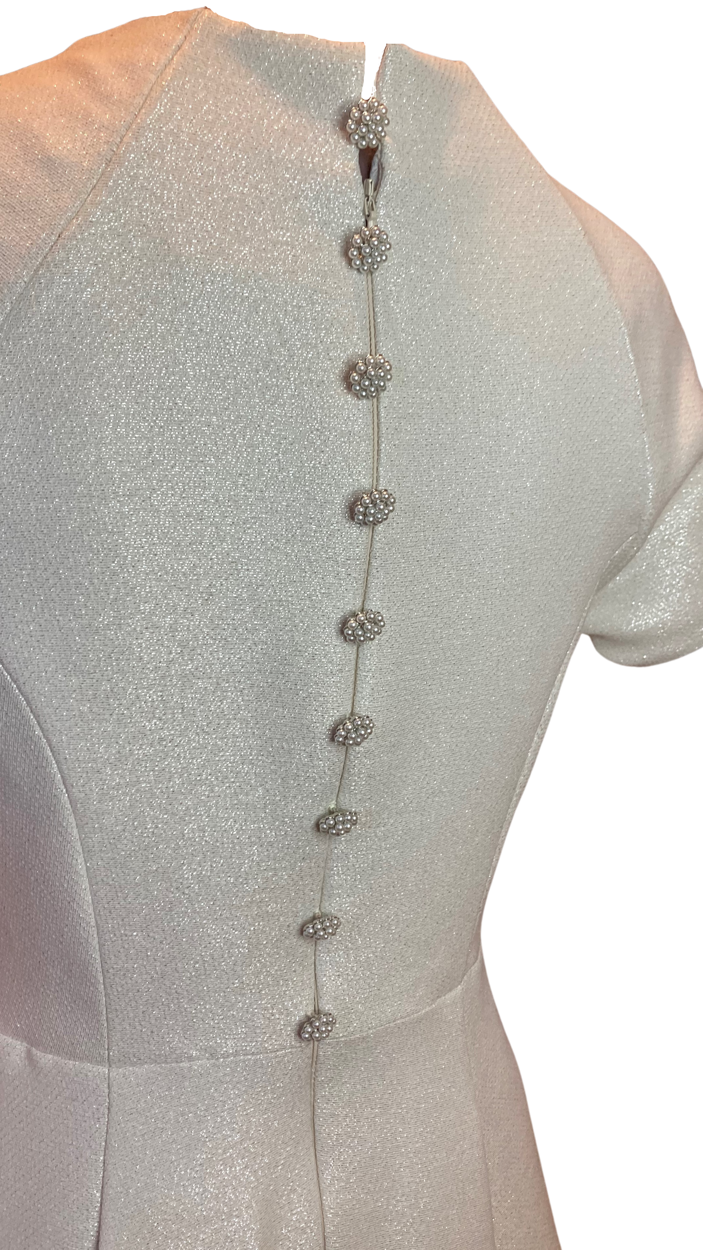 Vintage Inspired High Neck Dress in an Ivory coloured Jacquard with a Beautiful Metallic shimmer. The full swing skirt and nipped in waist are very flattering while the high neckline adds a demure elegance. The Pearl Cluster buttons highlighting the back zip adding extra luxury.