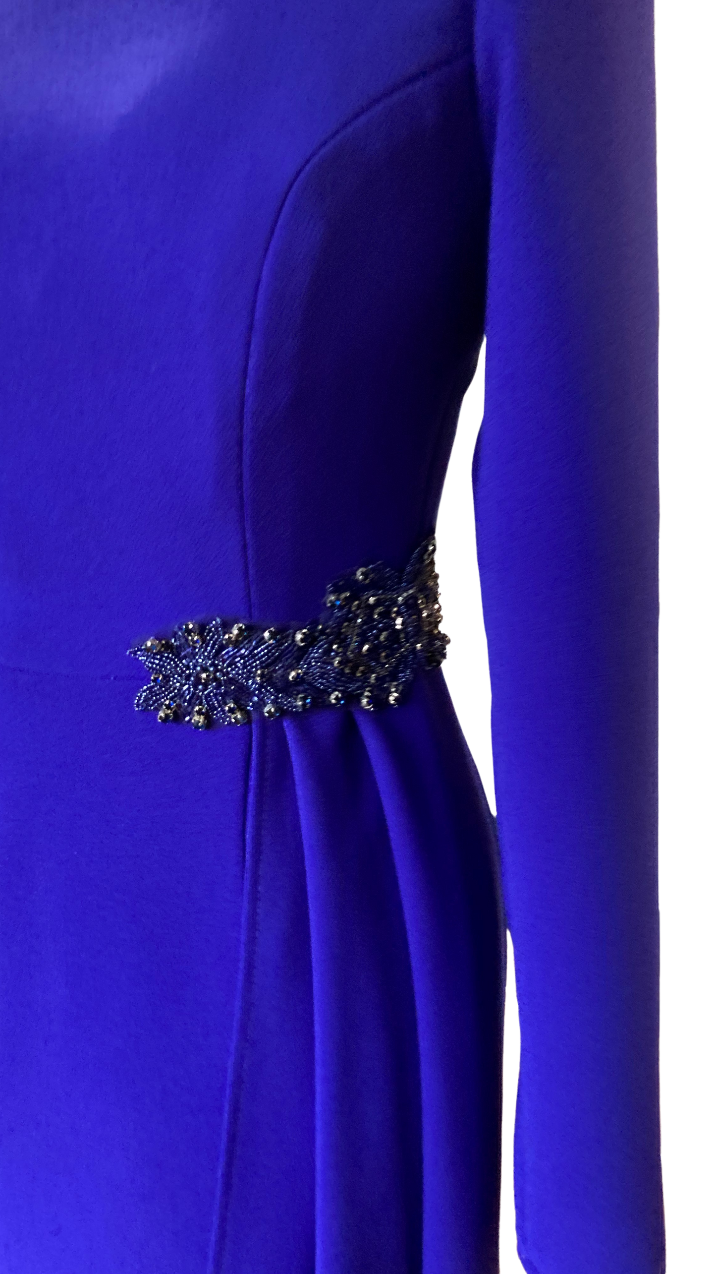 Sarah Side Drape in Byzantine Purple colour. This dress is a Classic and Elegant, tailored Dress, ideal for a mother of the Bride/Groom. Simple sleeve and neckline with a flattering side drape anchored with a Jewelled applique.