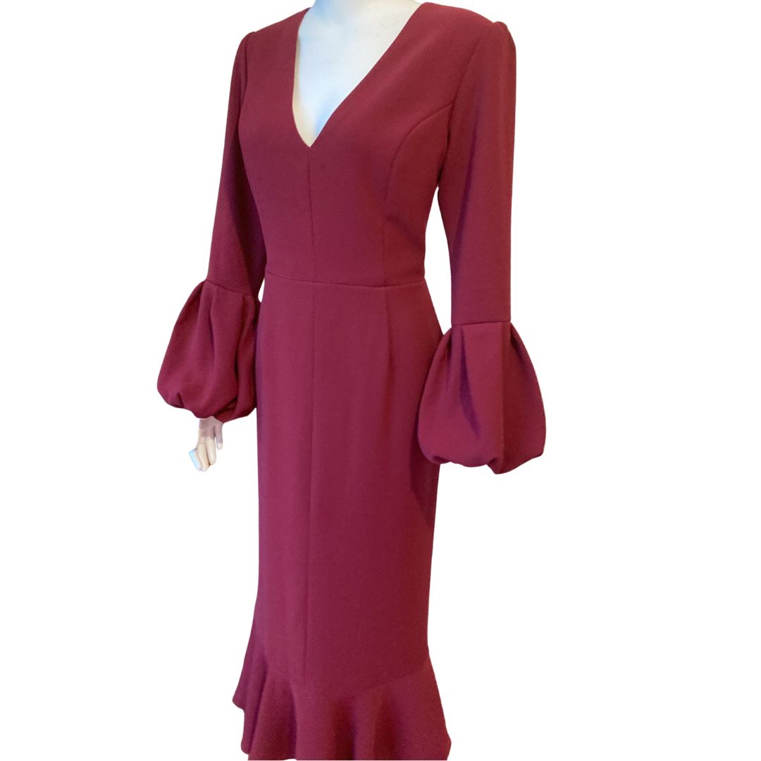 V Neck maxi with a sleeve finishing in a draped volume cuff. This fitted dress longer length is softened by a lower flounce creating a flirty finish