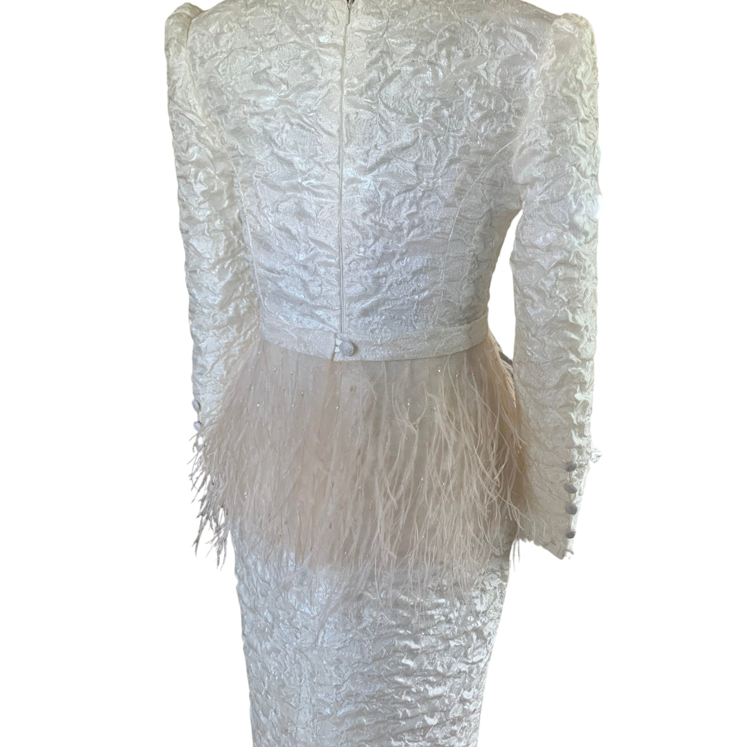 Warm Ivory tailored jacquard dress with a blush feather and bead detachable peplum.